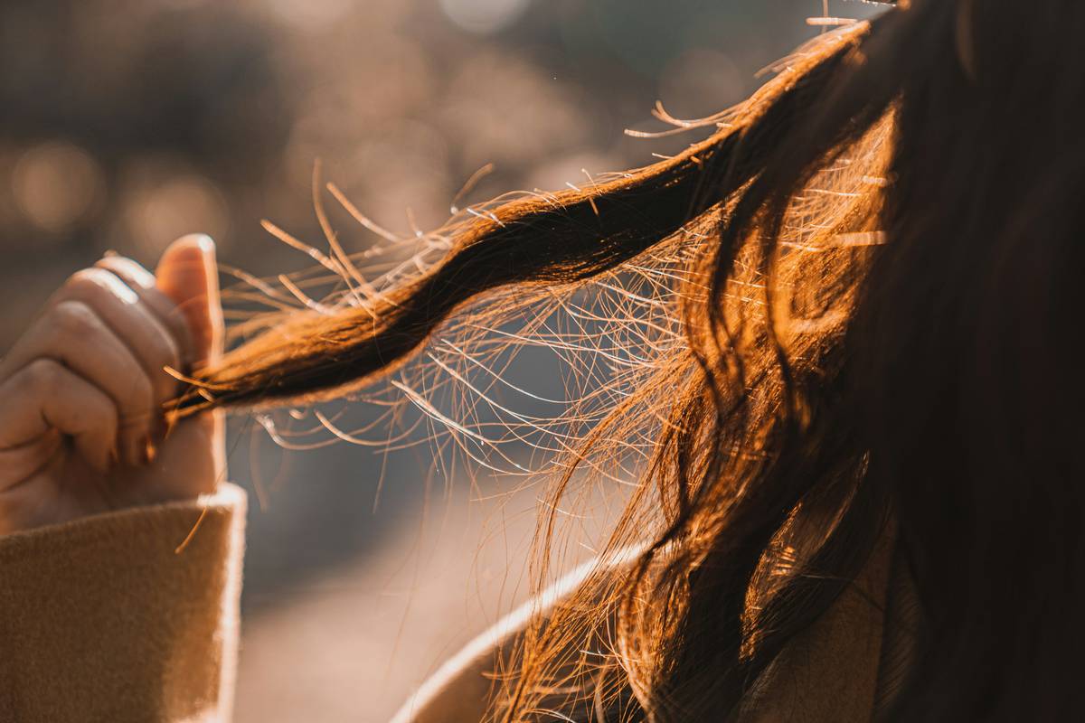 Woman gently combing wet hair with knot-free conditioner applied for easy detangling